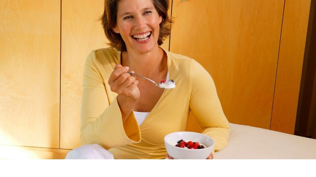 Woman happily eating her breakfast