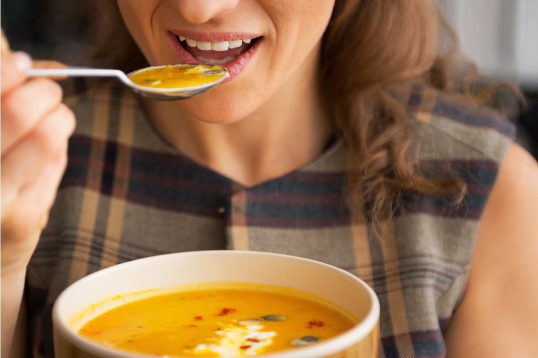 Lady eating a bowl of pumpkin soup